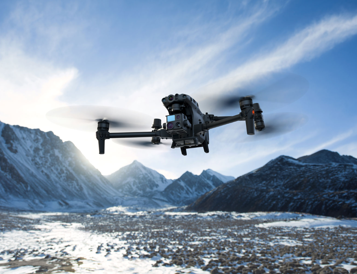 Show the Matrice M30T in action flying in the snowy mountains, doing aerial surveying